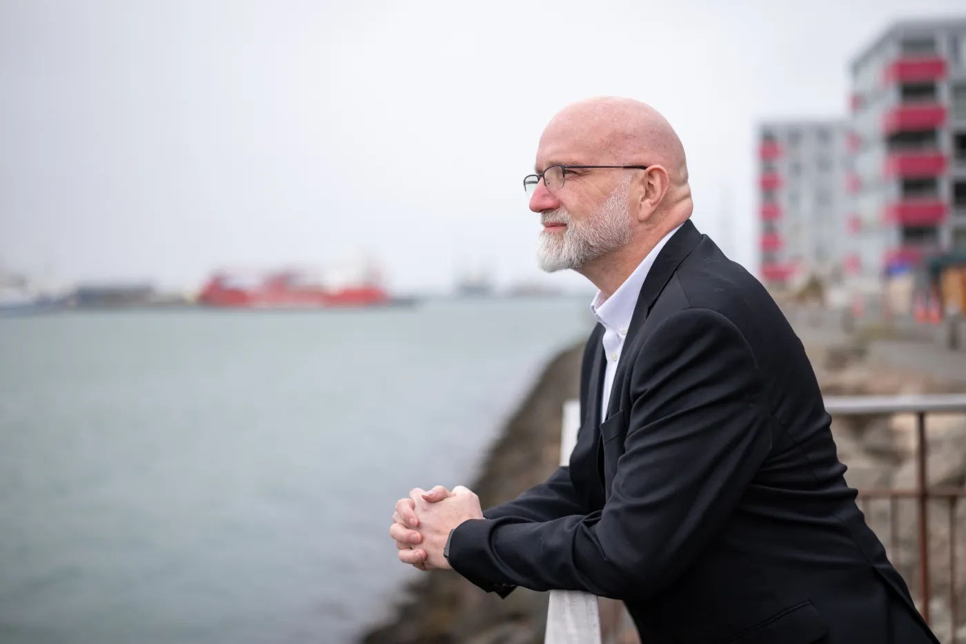 Gísli Rafn Ólafsson looking out over a harbor in Iceland