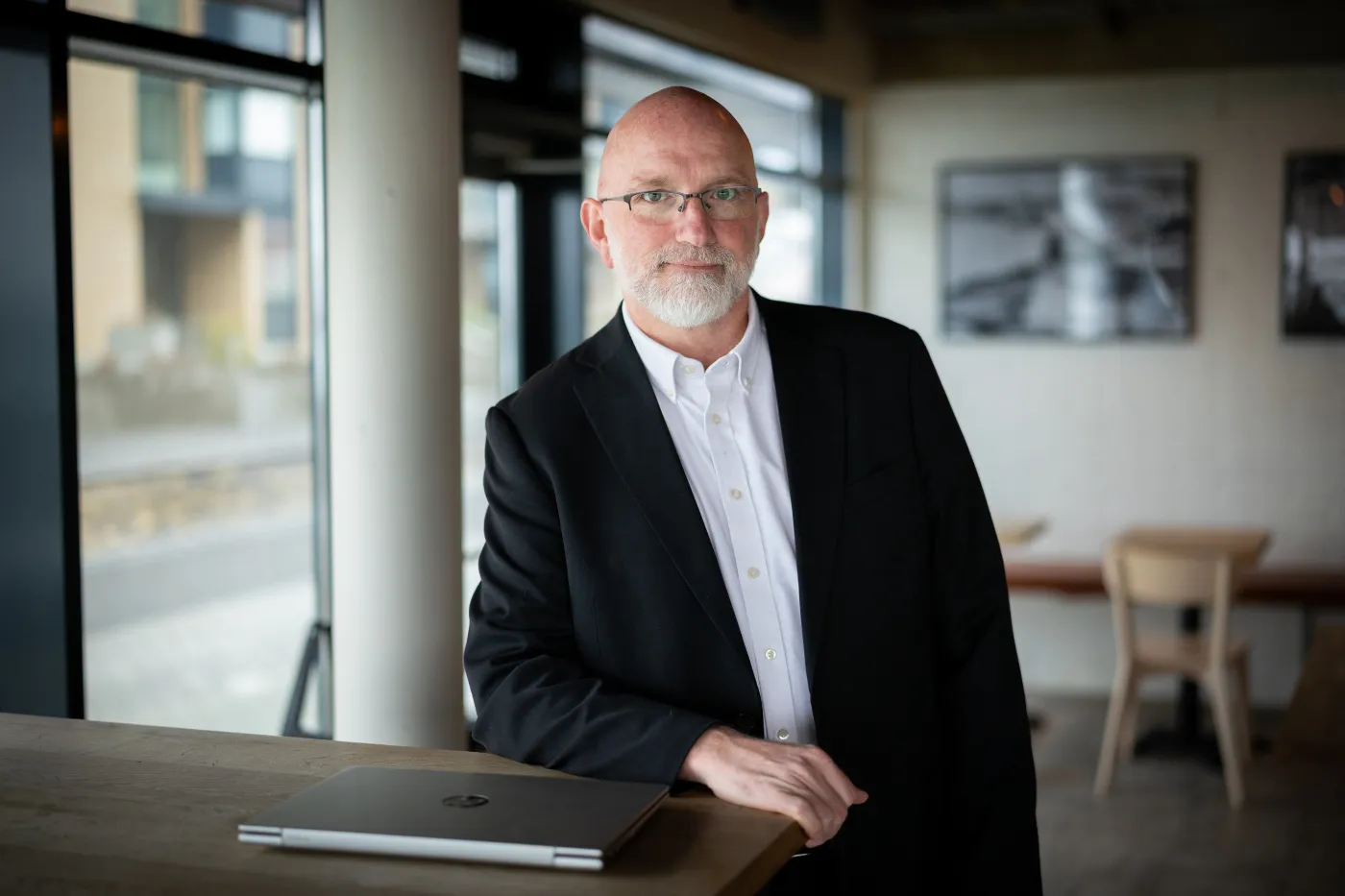 Gísli Rafn Ólafsson standing at a table with a closed laptop